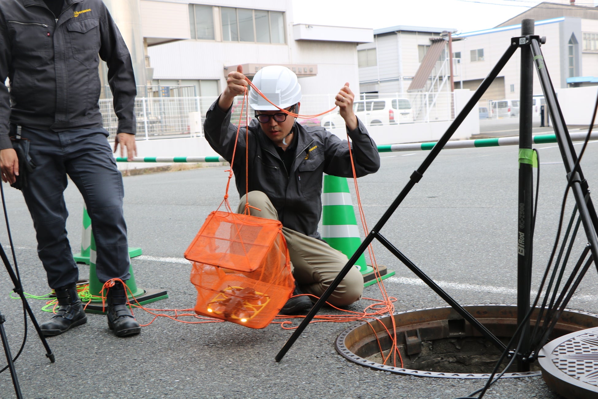 ドローンを下水道管に下ろす作業